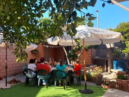 a group of people sitting at a table under an umbrella at Su Fassoi Cabras in Càbras