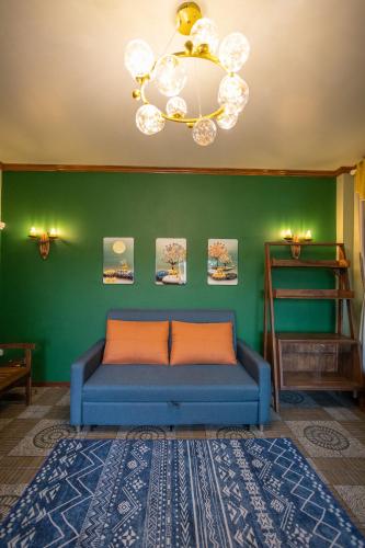 a blue couch in a room with a green wall at Mana-An Lake Hill Resort Villa in Chiang Mai