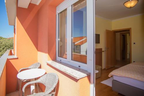 a room with a window and a table and chairs at Apartmani Miš Rab in Palit