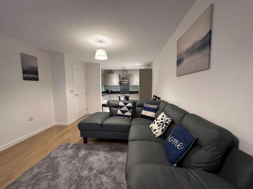 a living room with a black couch and a kitchen at Modern 2 bed 2 bath Flat Close to Train station in Belvedere