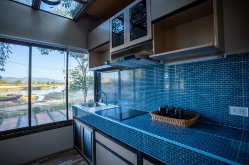 uma cozinha com um lavatório e uma grande janela em Mana-An Lake Hill Resort Villa em Chiang Mai