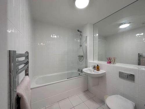 y baño con aseo, lavabo y ducha. en Modern 2 bed 2 bath Flat Close to Train station, en Belvedere