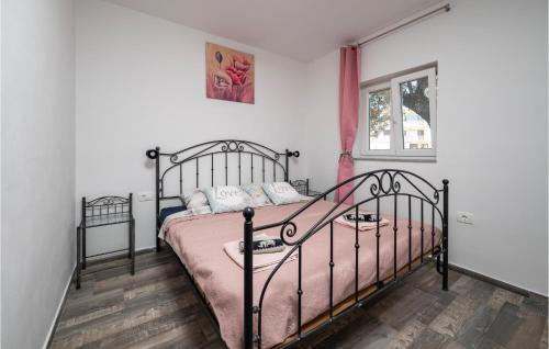 a bedroom with a black bed with pink sheets at 1 Bedroom Nice Home In Peroj in Peroj