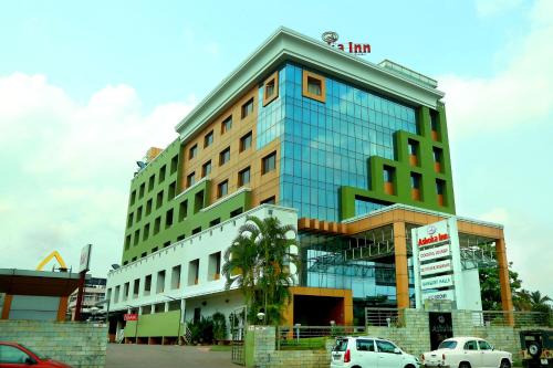 a tall building with cars parked in front of it at ASHOKA INN in Trichūr