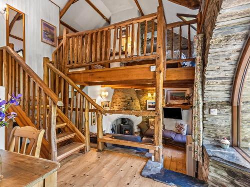 a spiral staircase in a log home with a living room at Ysgubor Ganol in Llanglydwen