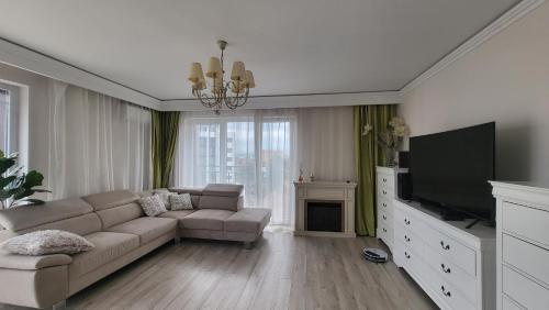 a living room with a couch and a flat screen tv at SIBIU Bach Penthouse in Sibiu