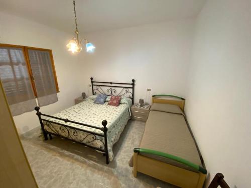 a bedroom with two beds and a chandelier at CASA SANT'ANNA in SantʼAnna Arresi