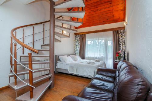 a living room with a spiral staircase and a bed at EcoRest - Likani Palace in Borjomi