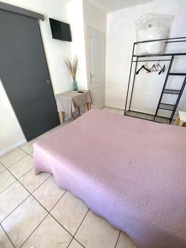 a bedroom with a pink bed and a table at Les Voyageurs in Charols