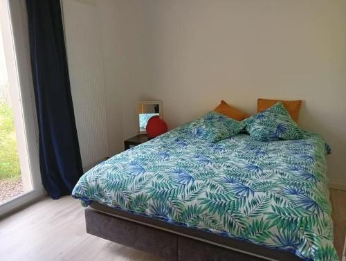 - une chambre avec un lit et une couette bleue dans l'établissement Maison Cluny, à Cluny