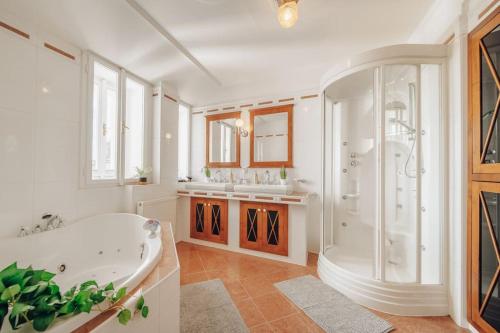 布拉格的住宿－Magnificent historical penthouse in the heart of Prague，白色的浴室设有浴缸和两个盥洗盆