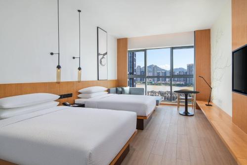 een hotelkamer met 2 bedden en een flatscreen-tv bij Fairfield by Marriott Zhuhai Xiangzhou in Zhuhai