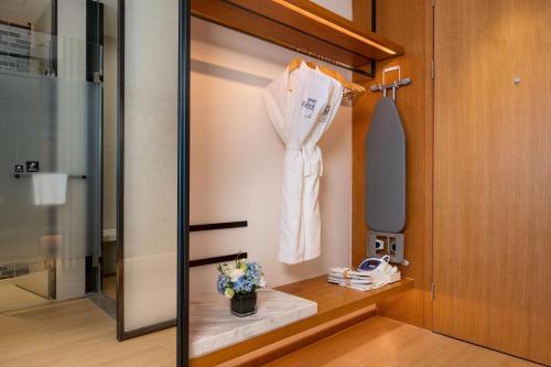 a dressing room with a robe hanging on a door at Fairfield by Marriott Zhuhai Xiangzhou in Zhuhai