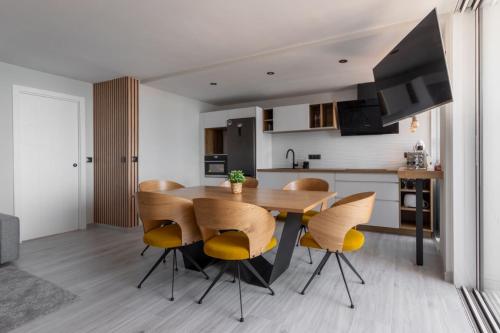 Una cocina y un comedor con mesa y sillas de madera. en Torre 2 planta 11, en Fuengirola