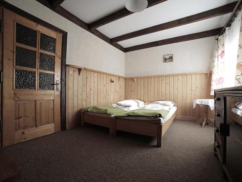 a bedroom with a bed and a wooden door at Pod Strzechą in Białka Tatrzańska