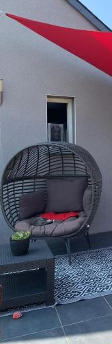 une chaise en osier avec des oreillers installés sur la terrasse dans l'établissement JOUANNEAU, au Mans