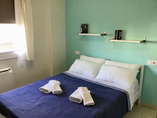 1 dormitorio con 2 toallas en una cama en Apartamento Tobias, muy cerca de la playa centro, en Villajoyosa