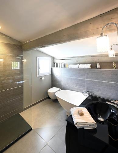 une salle de bain avec une baignoire, des toilettes et un lavabo dans l'établissement La Villa Moderna, à Robion