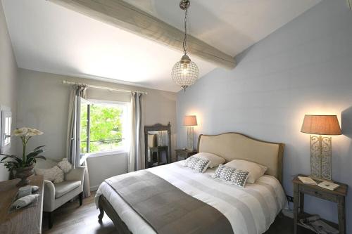 une chambre avec un grand lit et une fenêtre dans l'établissement La Villa Moderna, à Robion