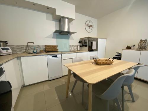 a kitchen with a wooden table and chairs in it at Beau duplex à 2 min du RER B in Sevran