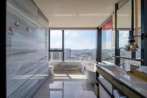 a bathroom with a toilet and a large window at Wuhan Marriott Hotel Hankou in Wuhan