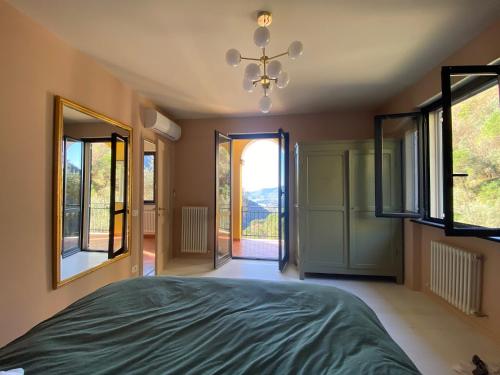 a bedroom with a bed and large windows at Villa Monte Rosa al Golfo by PortofinoVacanze in Rapallo
