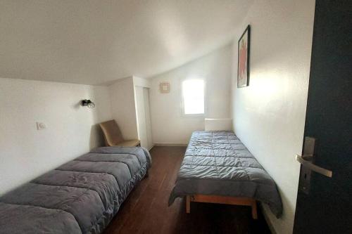 1 Schlafzimmer mit 2 Betten und einem Fenster in der Unterkunft Appartement dans village vacances in Ghisonaccia