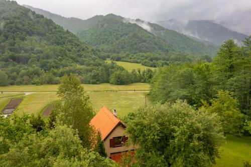 a house in a field with mountains in the background at Holiday House Sofia in Delnice