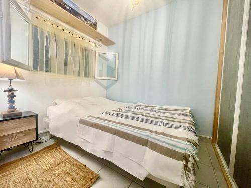 Grosseto-PrugnaAppartement cosy, vue mer à 5 min à pied de la mer的一间有床和窗户的小卧室