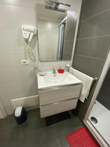 y baño blanco con lavabo y ducha. en La Rosa home, en Nápoles