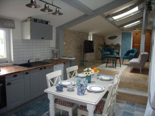 une cuisine avec une table et des chaises blanches ainsi qu'une cuisine avec une table et des chaises dans l'établissement chaivero, à Pineuilh