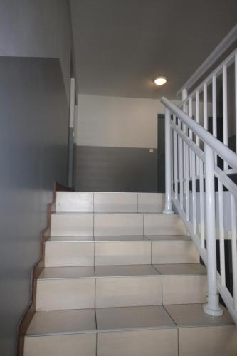 a staircase in a building with white rails and white stairs at chez Gérald in Noumea