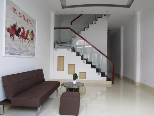 a living room with a couch and a staircase at HO GIA AN Home - Căn hộ yên bình in Can Tho