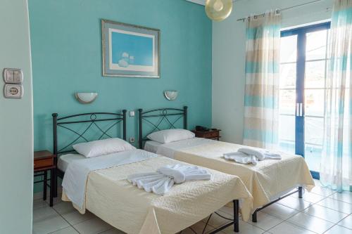 2 camas en una habitación con paredes azules en Mistral, en Souvala