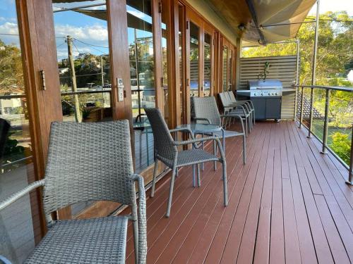 a porch with chairs and a table and a grill at Wanda House - Close to beach Linen Pets in Salamander Bay