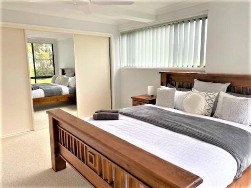 a bedroom with a large bed and a large window at Wanda House - Close to beach Linen Pets in Salamander Bay