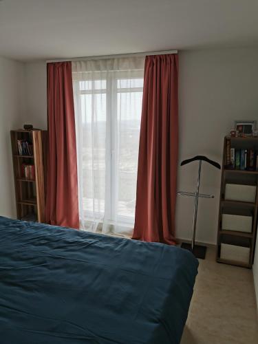 a bedroom with a bed and a window with red curtains at Villa Aura in Milna