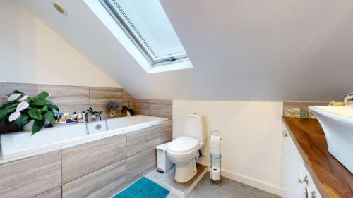 een badkamer met een toilet, een bad en een wastafel bij Love Lancing by the Sea with private Hot Tub sleeps 8 & plentiful free parking in Lancing