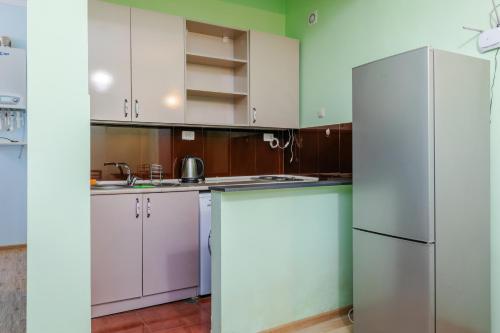 a kitchen with white cabinets and a refrigerator at EcoRest - Likani Palace in Borjomi