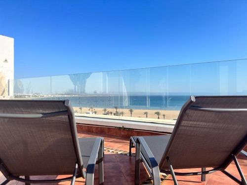 - deux chaises assises en face d'une vue sur la plage dans l'établissement Mauritania - Luxe - ocean view for 4 or 5 Px, à Agadir