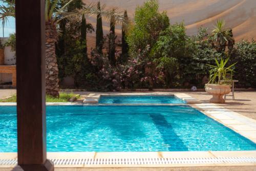 a swimming pool in a yard with trees and plants at Little Venice Chalet- Private Villa- Dead Sea Jordan in Sowayma