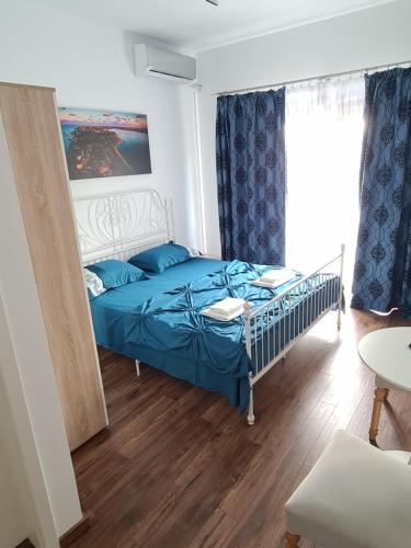a bedroom with a bed with a blue comforter at Vila SIA Eforie Sud in Eforie Sud