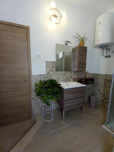 een badkamer met een wastafel en een spiegel bij Divina Cuspide in Guspini