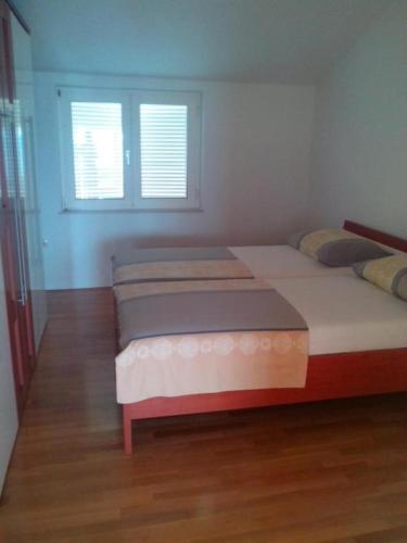 two beds in a room with two windows at Madunić in Podstrana