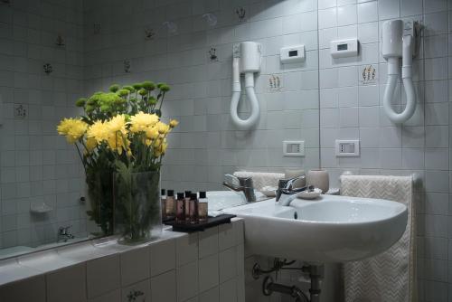 łazienka z umywalką i wazą z żółtych kwiatów w obiekcie Villa Curti w mieście Sovizzo