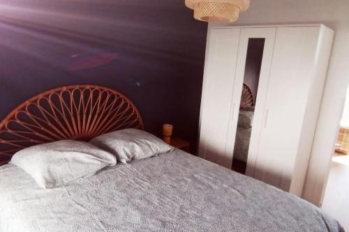 um quarto com uma cama com uma cabeceira de madeira em Appartement à 50 m de la plage em Audierne