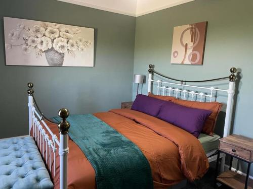 a bedroom with a bed with purple and orange at Southend, Mull of Kintyre, Campbeltown in Campbeltown