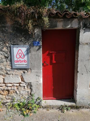 une porte rouge avec un panneau devant elle dans l'établissement Le gite de la Licorne, à Saint-Mihiel