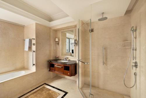 a bathroom with a shower and a sink and a tub at Grand Hotel Haikou - Managed by Accor in Haikou