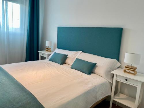 Un dormitorio con una cama grande con dos mesitas de noche. en VerdeMar 5 (Playa Puerto de Sagunto), en Puerto Sagunto